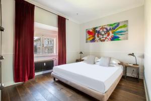 um quarto com uma cama branca e cortinas vermelhas em Alla Corte Guest House em Roma