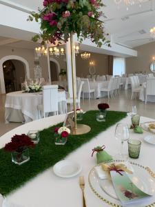 una mesa con mesas blancas con flores. en Villa Natia, en Mottola