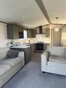 a living room with two couches and a kitchen at 2 Bedroom Villa - Lakeside Holiday Park in Merston