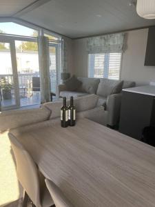 a living room with a table with bottles on it at 2 Bedroom Villa - Lakeside Holiday Park in Merston