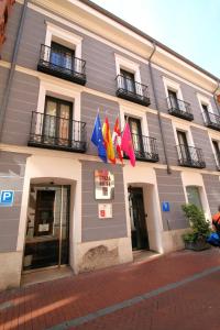 un edificio con banderas a un lado. en ELE Enara Boutique Hotel en Valladolid