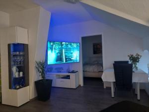 a living room with a large television and a table at Moderners Apartment am Hauptbahnhof in Minden in Minden