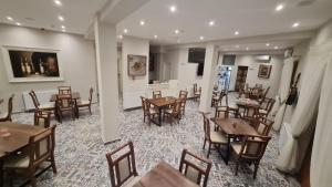 a dining room with wooden tables and chairs at Hotel Bujtina 31 in Korçë