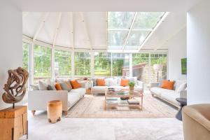 een woonkamer met witte meubels en een glazen plafond bij Le Clos d'Ully Chantilly in Ully-Saint-Georges