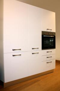 cocina con armarios blancos y microondas en Appartamento Signorile, en Cagliari