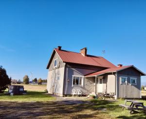 una pequeña casa con techo rojo en un campo en Koskela en Kalajoki