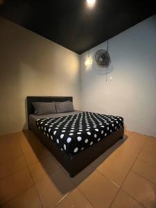 a bedroom with a bed with a black and white comforter at Ghazrins Garuda JB in Johor Bahru