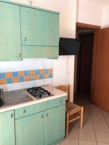 a kitchen with green cabinets and a stove top oven at Enjoy your stay in our nice flat with pool in Rosapineta