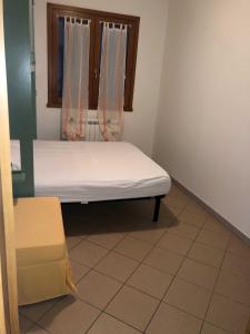 a small bed in a room with a window at Enjoy your stay in our nice flat with pool in Rosapineta