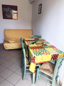 a table with a colorful table cloth on it with a couch at Enjoy your stay in our nice flat with pool in Rosapineta