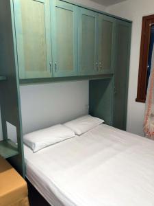 a bedroom with a bed with blue cabinets at Enjoy your stay in our nice flat with pool in Rosapineta