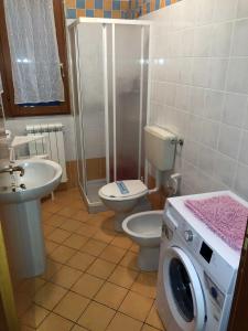 a bathroom with a toilet and a washing machine at Enjoy your stay in our nice flat with pool in Rosapineta