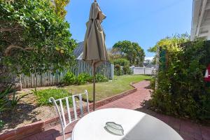 a table and an umbrella and a table and chair at Morningside Cottage in Tokai
