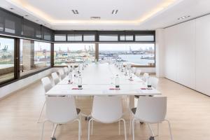 a long white conference room with a long table and white chairs at Hotel Cristina by Tigotan Las Palmas - Adults Only in Las Palmas de Gran Canaria