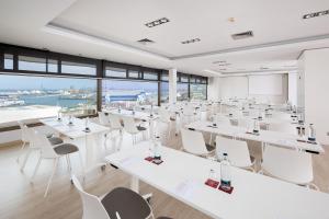 a room with white tables and chairs and a large window at Hotel Cristina by Tigotan Las Palmas - Adults Only in Las Palmas de Gran Canaria +37 photos