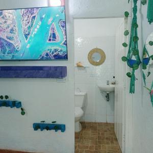 a bathroom with a toilet and a painting on the wall at Casa Margarita in Santa Marta