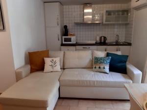 a living room with a white couch with pillows on it at Casa Bajo la Roca in Setenil