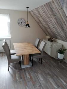 a dining room with a wooden table and chairs at Ferienwohnung Bergwiese in Schwarzenbach am Wald