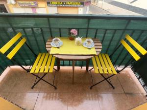 a yellow table and chairs on a balcony at Coqueto apartamento estación in Córdoba