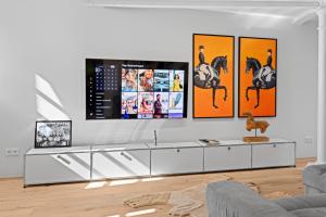 a living room with a tv on a white wall at Innenstadt- Parken- Nähe Rathaus in Augsburg