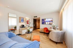uma sala de estar com um sofá azul e uma mesa em Bel Mon Resort em Rybnik