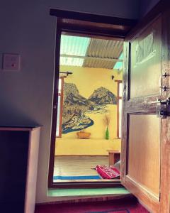 a door to a room with a painting on the wall at SpitiDiaries Homestay in Kaza