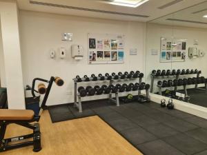 a gym with rows of dumbbells on a wall at Sunset Yas Island Studio near F1 and concerts in Abu Dhabi