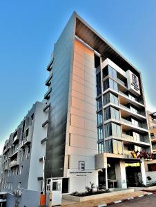 卡薩布蘭卡的住宿－肯茲西迪馬魯夫酒店，街道上一座高大的公寓楼,设有玻璃窗