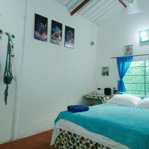 a bedroom with a blue bed and a window at Casa Margarita in Santa Marta