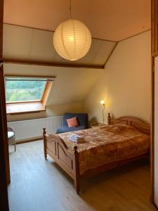 ein Schlafzimmer mit einem großen Bett und einem Fenster in der Unterkunft B&B De Schouw in Noordgouwe