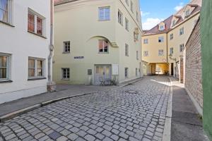 a cobblestone street in a city with buildings at Innenstadt- Parken- Nähe Rathaus in Augsburg