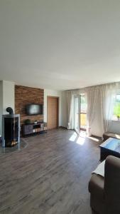 an empty living room with a couch and a tv at Ferienwohnung am Mondsee in Mondsee