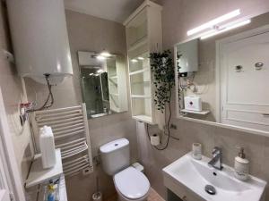 a bathroom with a white toilet and a sink at Flowers Family Home in Sopelana