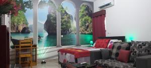 a living room with a large window with a painting on the wall at Magnifique Studio Meuble in Abidjan