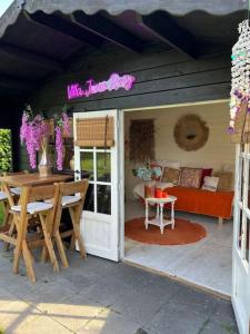 een patio met een tafel en een bank bij Villa June Rosy in Wijchen