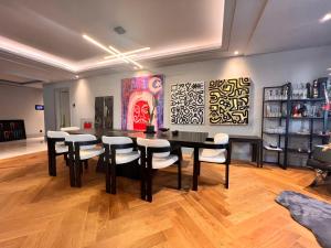 uma sala de jantar com uma mesa preta e cadeiras em Amazing Luxury Large 4 Bedroom Apt Istinye Park 1 min 250m2 em Istambul