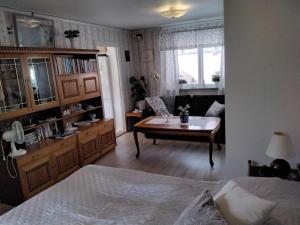 a bedroom with a living room with a table and a couch at Bo i Trelleborg in Trelleborg