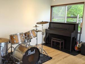 a room with a drum set and a piano at Mountain View Totoro - spacious & sunny in Yoichi