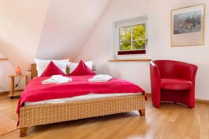 1 dormitorio con cama roja y silla roja en Natourlust Preetz - Die kleine Rote, en Burtevitz