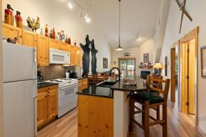 a kitchen with wooden cabinets and a white refrigerator at 2674 Tenderfoot Lodge Condo in Keystone