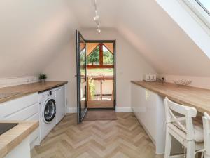 a laundry room with a washer and dryer at Spicery Barn Loft in Exeter