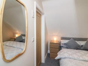 a bedroom with two beds and a mirror at Spicery Barn Loft in Exeter