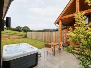 a hot tub in a yard with a table at Spicery Barn Loft in Exeter