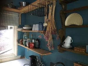 a kitchen with wooden shelves on a blue wall at Sjöstuga, Archipelago Beach House in Värmdö