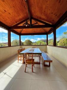 a dining room with a table and chairs and windows at Sitio Recanto Maçussa in Ouro Preto