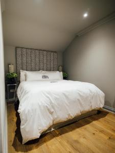 a bedroom with a large bed with white sheets at Ripple Cottage in Ripple