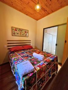 um quarto com uma cama com almofadas em Sitio Recanto Maçussa em Ouro Preto