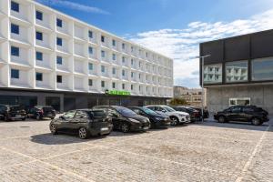 孔迪鎮的住宿－B&B HOTEL Vila do Conde，停在大楼前停车场的一排汽车