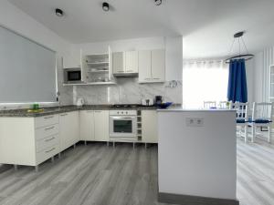 a kitchen with white cabinets and a counter top at Newly renovated apartment with 2 terrace, 2 bedroom, 5min beach in Puerto de Santiago