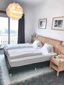 a bedroom with a large bed and a chandelier at Wildauers Haidenhof STAY & SLEEP in Lienz